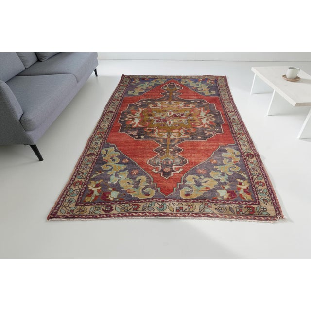 This is a vintage Turkish Oushak rug from the Mid 20th Century. The piece was hand-knotted.