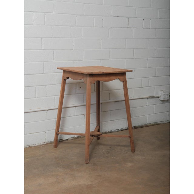 A small wooden table defined by its slender proportions and straightforward construction. The rectangular top is formed...