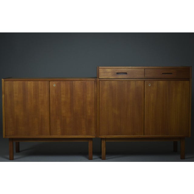 A modular set from the 1960s comprising two identical teak sideboards and a low mobile drawer unit. Each sideboard...