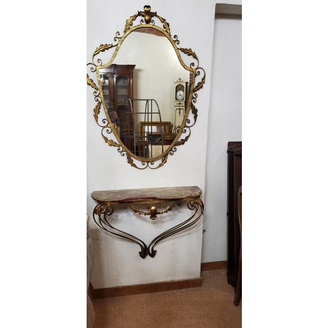 Console with mirror from the 50s, Italian manufacture, attributable to the designer Pier Luigi Colli, in gilded wrought...