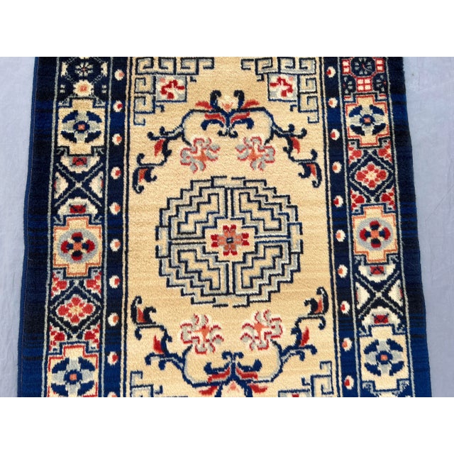 This vintage Chinese hand-knotted wool rug displays a refined Art Deco-inspired medallion design with a soft cream field...