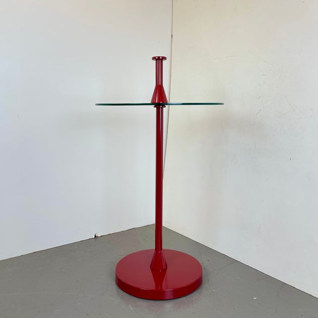 Eye-catching side table made of a red lacquered central foot with a floating glass table top and an hidden stone...