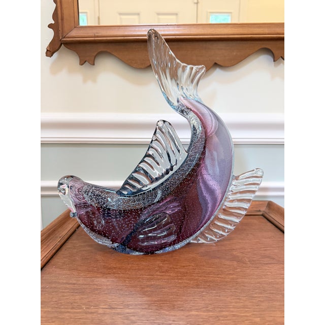 A dramatically sculptural Murano art glass fish caught mid-leap, rendered in deep amethyst and lavender sommerso glass...
