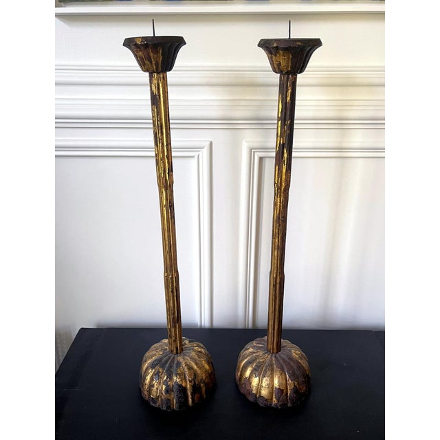 A tall pair of Japanese carved wood candle holders circa early 19th century (late Edo Period). The pair is carved in the...