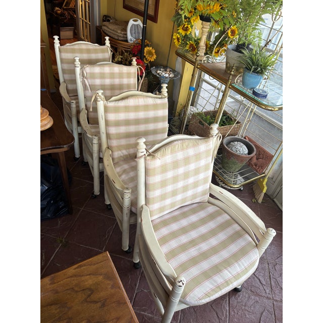 Featuring ladder back and rush seats with exaggerated arm in distressed cream finish. Ball style finial on arms and turned...