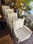 Featuring ladder back and rush seats with exaggerated arm in distressed cream finish. Ball style finial on arms and turned...