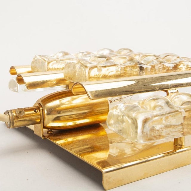 Wall wall lamp, molded glass mounted on brass, made by orrefors in Sweden in the 1960s. Good condition. This piece has an...