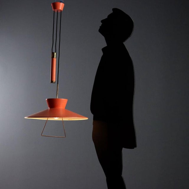 Vintage lamp in orange lacquered metal on the outside and white on the inside with a pull-down mechanism. Good condition....