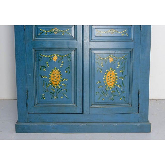 French Armoire all blue painted and patinated with green and yellow floral decoration. Two doors with one key. Four...