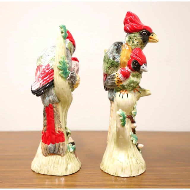 A pair of porcelain figurines depicting female cardinals on tree branches. Multi-colored porcelain of primarily red, black...