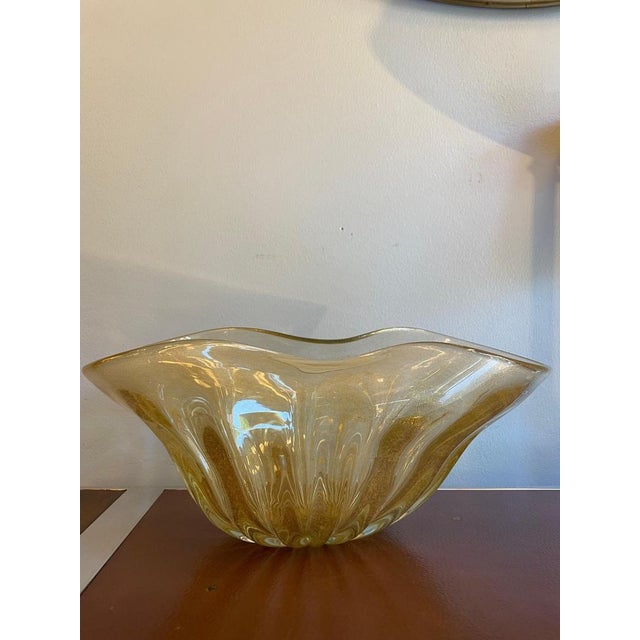 1970s Murano glass centerpiece/vase in "honey gold" tone. Characterized by a free, wavy form, it features a ribbed texture...