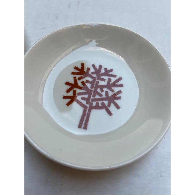 A matching pair of round porcelain butter plates from The Four Seasons restaurant in New York. Each plate features the...