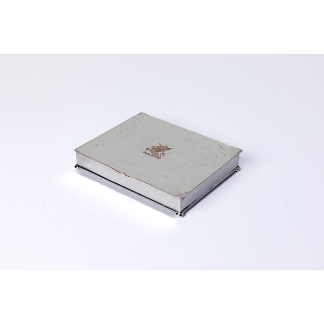 Description: Silver Covered Box with Crest Date: Mid Century Material: Silver over Copper Origin: American Dimensions: 6"L...