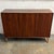 A Danish teak three-door cabinet dating to the 1940s, with a clean rectangular case, raised legs, and simple paneled...