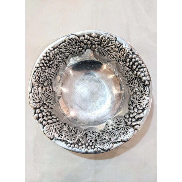 Beautiful polished metal bowl, featuring intricate grapevine detailing. Crafted in Mexico and signed by maker on bottom.