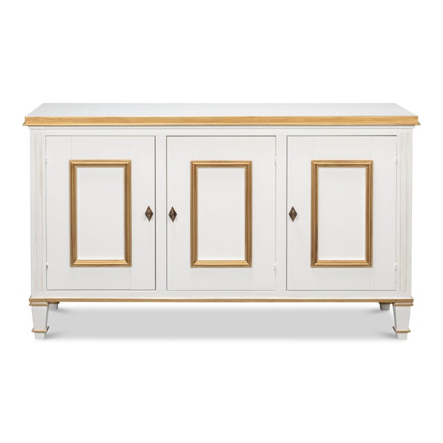 Gilt outlines applied panel moldings against soft white, giving the three-door facade an architectural rhythm. Three doors...