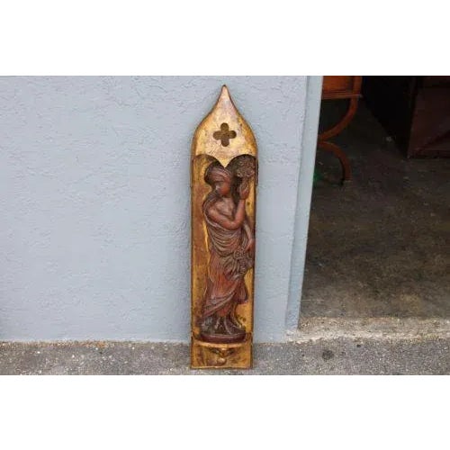 A lovely Mid Century heavy carved detailed wood sculpture of a demure girl, she is standing under a handmade steel...