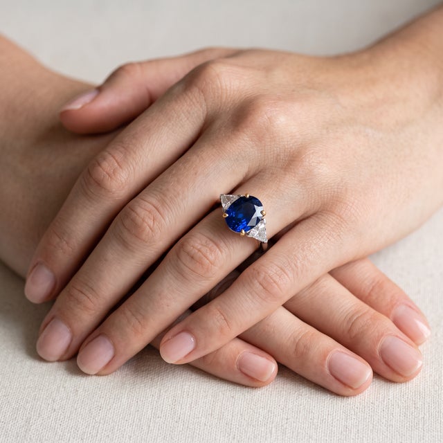A vintage trilogy ring from circa 1990 in 18k gold, centered on a natural unheated Madagascar sapphire of 3.55 carats — a...