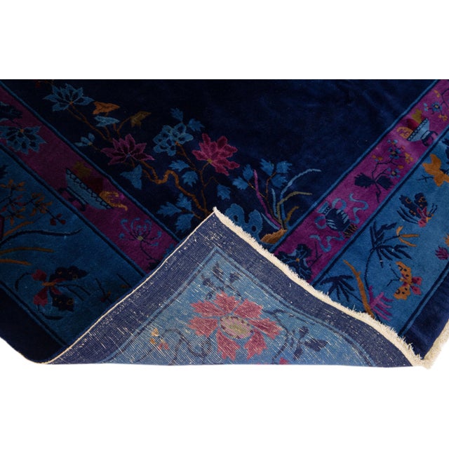 Beautiful antique Art Deco hand-knotted wool rug with a navy blue color field. This piece has a purple frame with multi-...