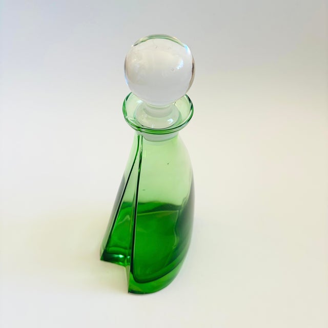 A vintage mid century art glass decanter. Beautiful vibrant green color to the glass with a clear round stopper. Unique...
