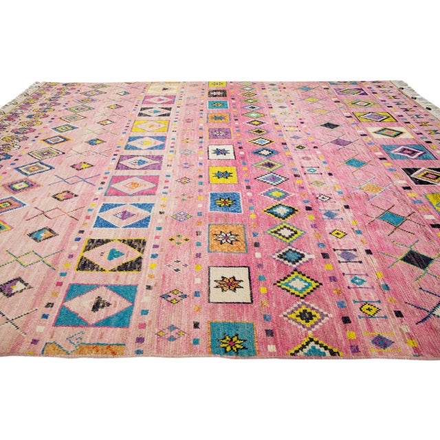 Beautiful moroccan berber style hand-knotted wool rug with a pink field. This piece has multicolor accents in an all-over...