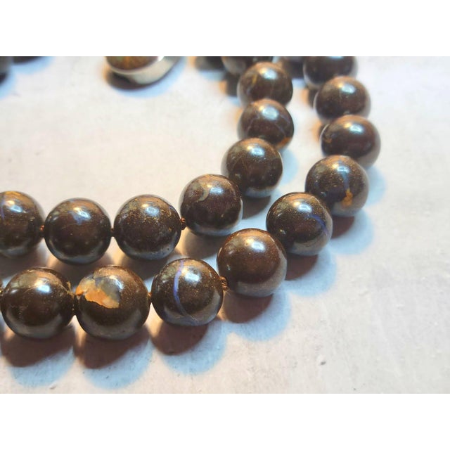 The necklace is 19 inches (48 cm) long, and the smooth round beads are 14mm in size. Boulder opals come from Andamooka,...