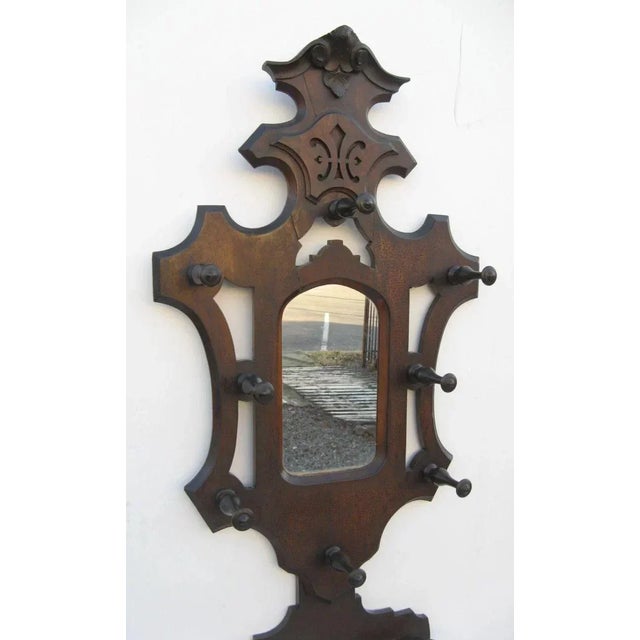 W 280 American walnut hall tree with arched mirror and coat pegs and stick stand. Old finish. Copper liner for umbrellas....