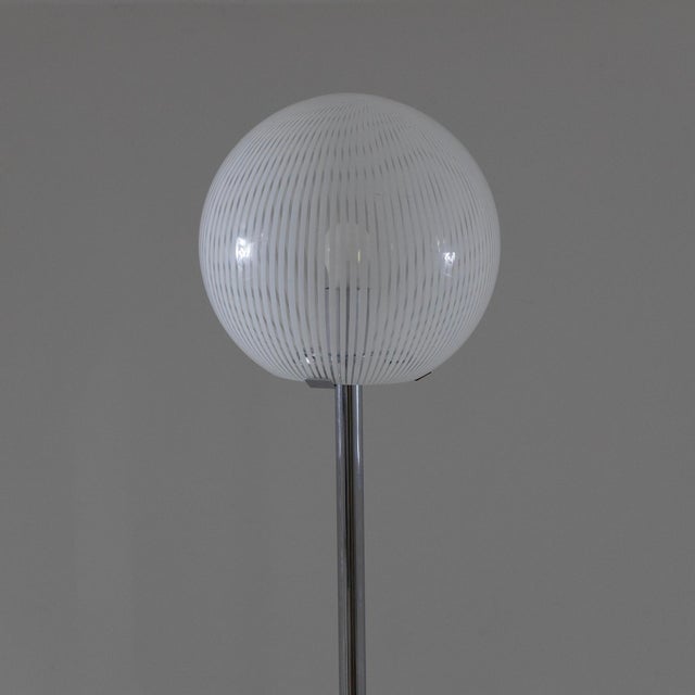 Floor lamp with a black embossed metal base, a chrome-plated telescopic stem with the Venini hallmark, and a glass...