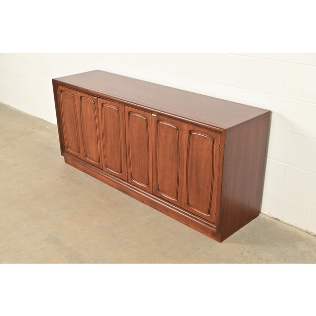 An exceptional Mid-Century Modern sculpted walnut sideboard, credenza, or bar cabinet By Broyhill Premier "Emphasis"...