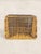 A charming English wicker storage basket featuring a handwoven rectangular form and turned wooden handles. Its warm honey-...
