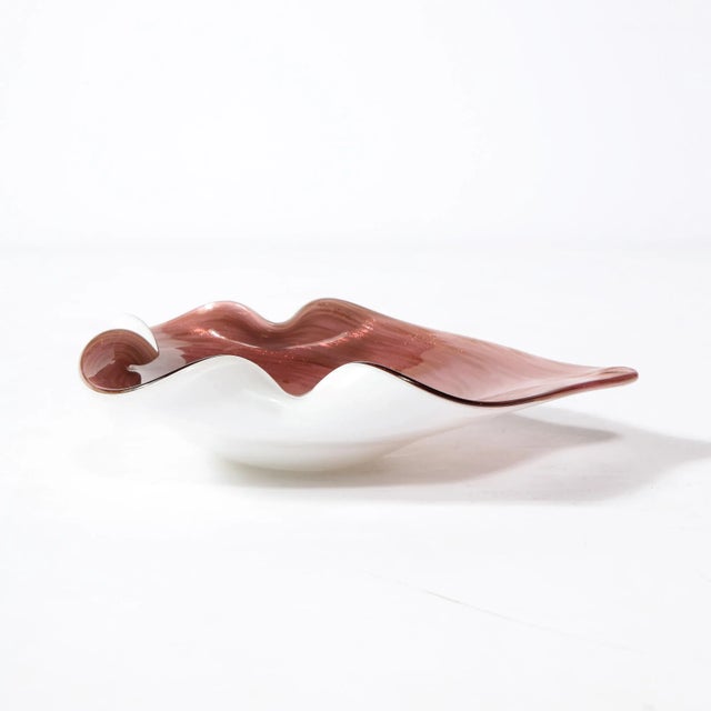 A stunning Hand-Blown Murano Glass Dish originates from Italy Circa 1960, rendered in a stunning amethyst hued glass, spun...