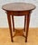Elegant French Neoclassical side table dating from the 20th century, featuring a round sunburst veneer top and refined...
