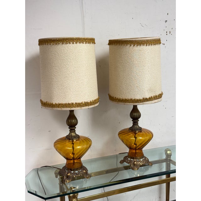 Design Plus Gallery presents a pair of Hollywood Regency Sculptural Glass Table Lamps. This pair showcases sculptural...