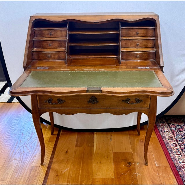 Charming antique French secretary desk with a warm, timeworn wood patina, graceful cabriole legs, scalloped details, and...