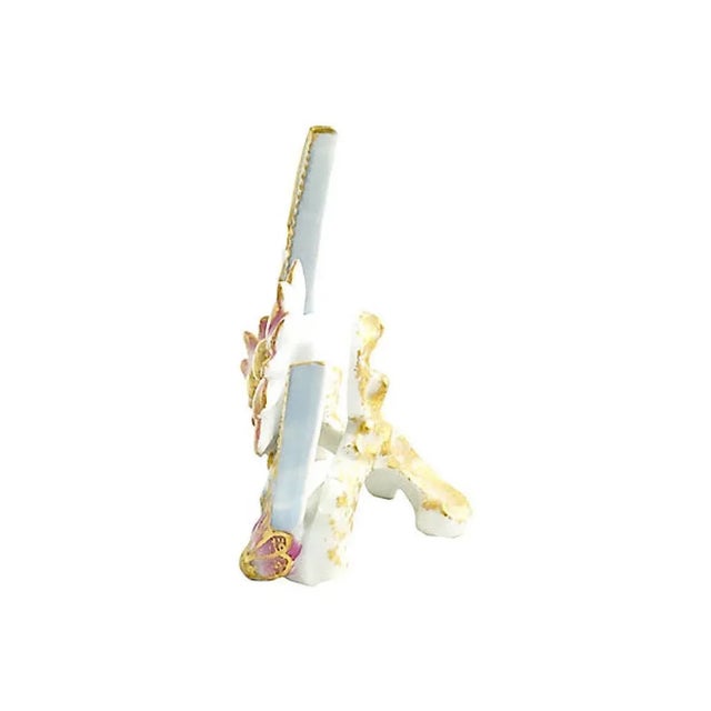 Porcelain menu holder featuring a pale blue crescent moon with gold beading on inner edge. Accented with three pink and...