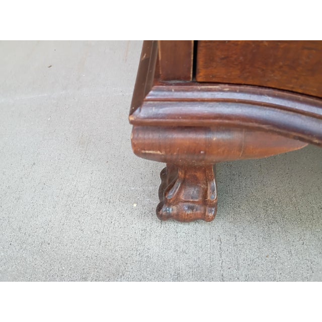 Elegant vintage Chippendale-style slant-front secretary desk featuring a rich mahogany-tone finish, gracefully shaped...