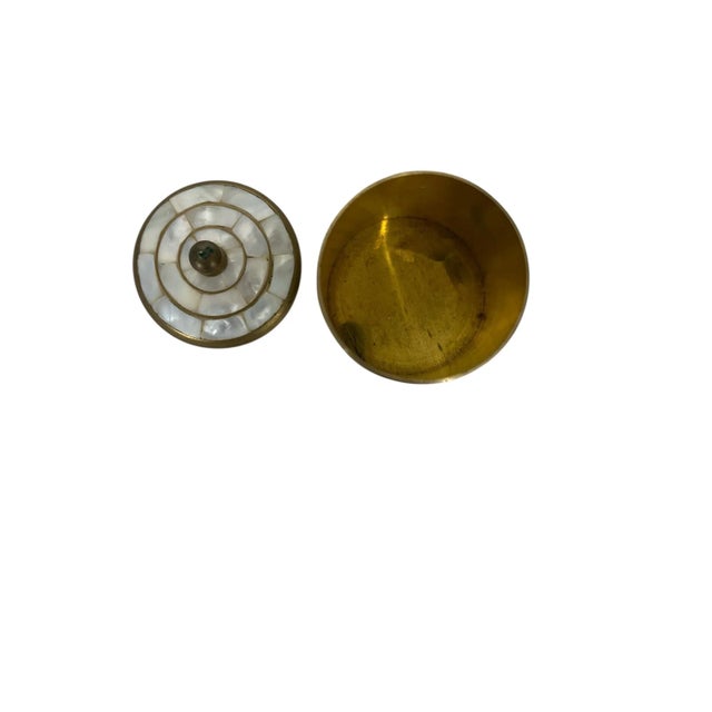 Vintage brass and mother of pearl trinket box. Great way to hide small clutter, matches, etc. Measures 3” diameter x 3.5” h.