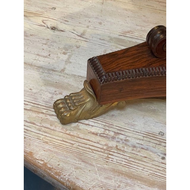 The product is a 19th century English Regency rosewood and brass inlaid side table. This elegant piece of furniture...