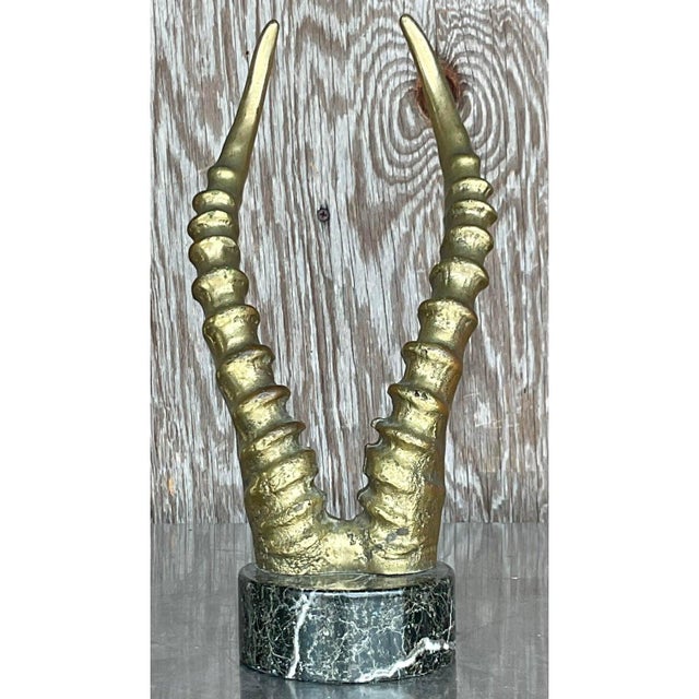 This striking mid-century sculpture features a dramatic representation of antelope horns, cast in bronze and mounted on a...