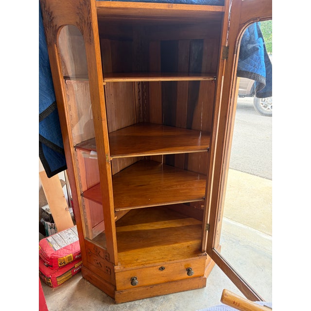 A beautiful and unusually compact antique Gold Oak corner china cabinet dating to approximately 1895-1910. Designed to fit...