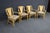 Set of four MCM-style bamboo and rattan fan back armchairs featuring sculptural curved arms, wrapped rattan detailing, and...