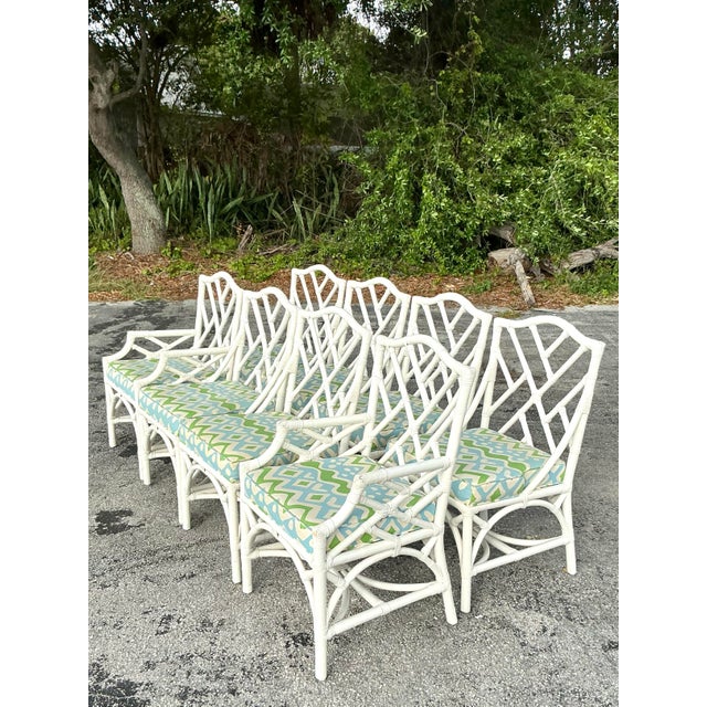Enhance your dining space with this stunning set of eight vintage coastal Chinese Chippendale rattan dining chairs....
