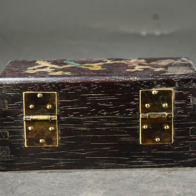 This charming Chinese jewelry box is a perfect example of traditional Asian craftsmanship. The box features a dark, richly...