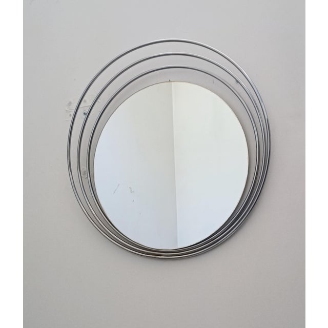 Magnificent space age design mirror. Italy, 1970s. Chrome-plated metal frame. The off-center glass is surrounded by three...
