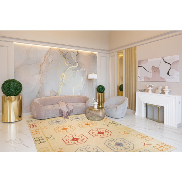 A handwoven wool flatweave, made in India and measuring 5'6"' x 10'. Floral drawing carried across the field inside a...