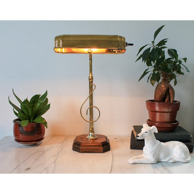 Vintage brass adjustable musical note piano lamp with wood base. No makers mark. Some age wear to brass finish and wood...