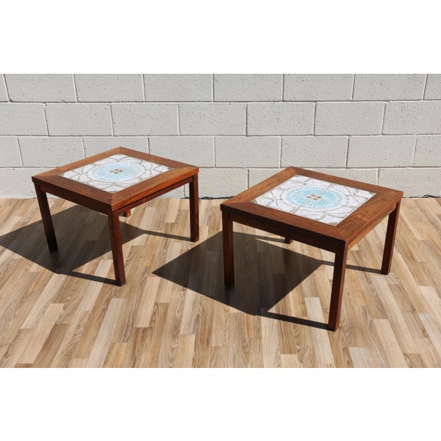 Beautiful pair of Danish modern rosewood side tables dating from the 1970s, featuring striking decorative ceramic tile...