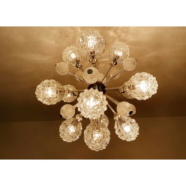 Large Sputnik pendant light featuring 25 spokes mounted on a black enameled core and glass shades. Dimensions 76 cm /...