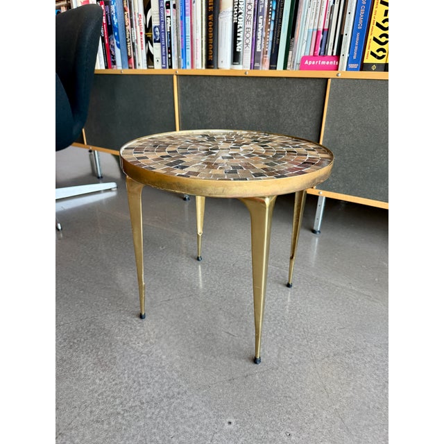 This 1960s occasional table features a hand-set glass mosaic tile top in a series of concentric earth-toned patterns....