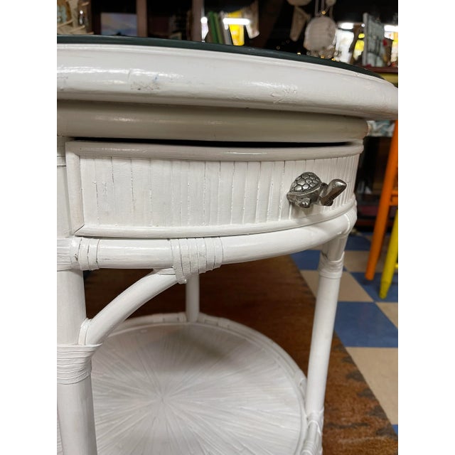 This bamboo and rattan table is painted white for a cool coastal vibe. The silver turtle knob really adds personality, and...